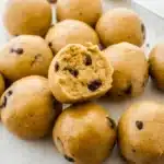 Cookie dough protein bites stacked on parchment paper