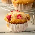 Strawberry protein muffins stacked on rustic table