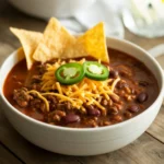 Crockpot chili con carne topped with cilantro and sour cream
