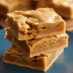 Delicious chewy pumpkin blondies served on a plate with autumn leaves