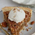 Maple pecan pie with brown sugar crust on a wooden table.