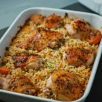 Oven baked chicken served with perfectly cooked rice on a plate.
