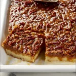 Delicious pecan pie cheesecake bars topped with pecans and caramel sauce
