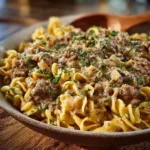 Creamy ground beef stroganoff served with pasta and garnished with parsley.