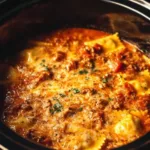 Crockpot Ravioli Lasagna layered with cheese and marinara sauce in a slow cooker