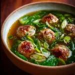 Delicious bowl of Chicken Meatball Soup garnished with herbs and vegetables