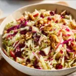 A bowl of vibrant cranberry apple coleslaw with fresh ingredients.