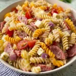 Bowl of colorful Grinder Pasta Salad featuring fresh vegetables and dressing