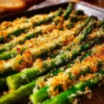 Baked Parmesan Asparagus on a serving dish garnished with herbs