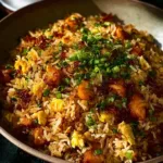 Plate of Bang Bang Fried Rice garnished with vegetables and herbs