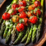 Plate of perfectly roasted asparagus garnished with herbs and lemon.