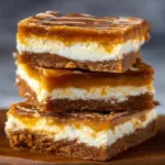 Caramelized pumpkin cheesecake bars on a plate with a drizzle of caramel