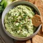 Bowl of Herby Avocado Egg Salad with fresh herbs and eggs.